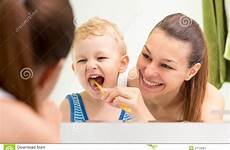 mother brushing teeth teaching kid