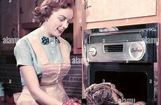 1950s apron housewife woman wearing oven smiling stock mitts taking alamy