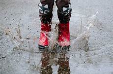 boots puddle splashing wet rain weather fun rubber den make red stocksy school choose board