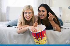girls scared watching film two popcorn eating portrait