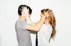 couple hair playing each others flirtatiously front background stocksy