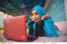 scarf muslim hijab laptop having computer working head woman happy beautiful networking internet using fun outdoors lifestyle portrait young enjoying