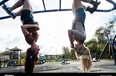 upside down hanging girls playground teenage two year old alamy