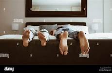 feet sleeping bed people different positions alamy two