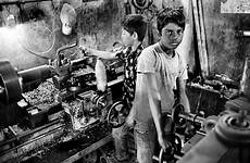 child labor india factory working machines seams behind boys