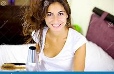 smiling happy hair long blow drying brunette bed cute wind camera looking woman stock
