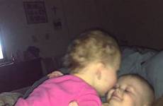 sister brother kissing little baby