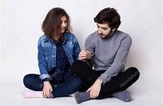 sitting together two people couple touching each other holding happy stock hand hands young floor crossed legs bearded girlfriend man