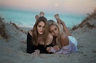 Zwei Frauen liegen am Strand im Sand