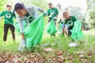 Environmentalist volunteers picking up trash in field - Stock Photo ...