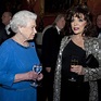 La Reina Isabel charla con Joan Collins en una recepción en Buckingham ...