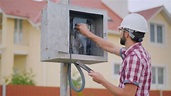 A Man Checks the Meter Reading Electricity in the Cottage Stock Photo ...