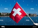 La bandera suiza, la bandera de Suiza, volando sobre el Lago Geneva ...