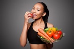 Happy healthy black asian woman eating vegetables - Tamborello Dental ...