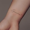 "Gracias" lettering tattoo on the wrist.