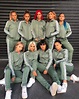 a group of women in matching tracksuits posing for a photo