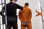 back view of prison guard leading criminal in handcuffs - Stock Photo ...