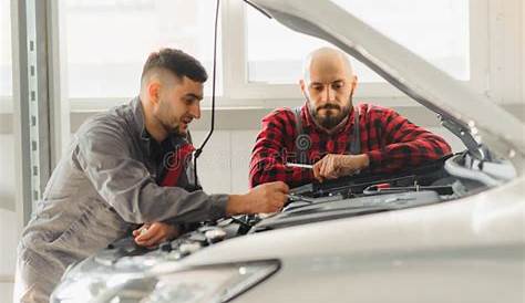 Auto Mechanics with Tools Near Car in Service Center Stock Image