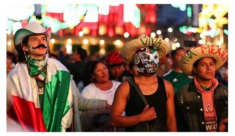 Un grupo de mexicanos plantean en el traje típico delante del stand de