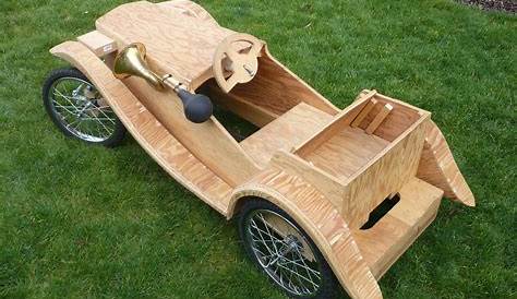 a wooden toy car sitting in the grass