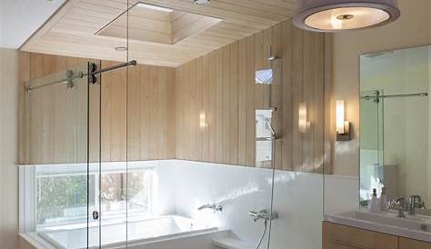 Soaking tub in an expansive, glass-enclosed shower with dual shower