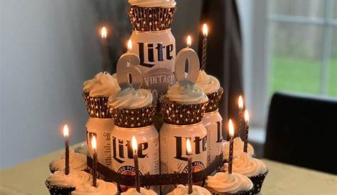 two bottles of heineken beer sitting on top of a cake
