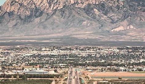 an aerial view of a highway in the desert with mountains in the backgroud