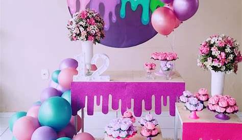 a table topped with lots of different colored paper fans and tassels on