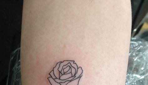 Rose holding hand tattoo on the right inner arm.