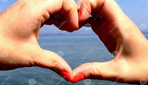 Woman`s Hands Shaping A Heart Symbol On The Pink Background Stock Image