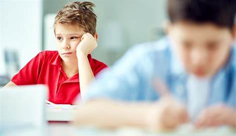 Niño aburrido haciendo la tarea o sentado en una aburrida lección