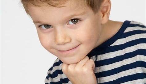 3-jähriger Junge, mit zu großen Turnschuhen, lächelt