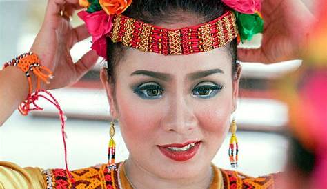 a woman with flowers in her hair is posing for the camera while wearing