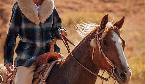 South Dakota's Governor Kristi Noem holds the U.S flag riding a horse