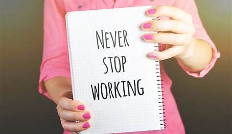 Woman Holding Never Stop Working Print Notebook · Free Stock Photo