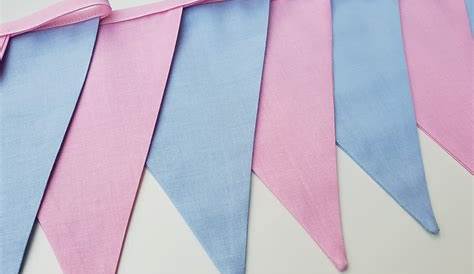 some pink and blue pennants are hanging on a white sheet with light