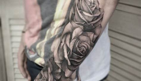 a man with a black and white rose tattoo on his arm