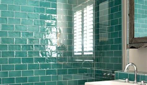 Bathroom With Bright Teal Tiles On The Wall Accented With White Grout