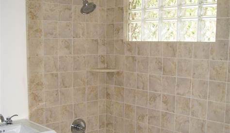 Bathroom with bathtub and gray subway tile shower surround with niche
