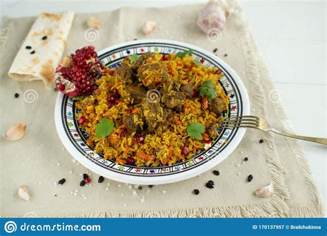Dish Of Oriental Cuisine Pilaf With Lamb In A Pan On A White