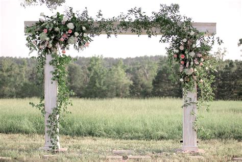 White Wooden Wedding Arch With Greenery And Flowers
