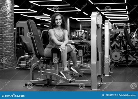 Sexy Fitness Brunette Girl Zit In Trainingsuitrusting Voor Benen In Gym