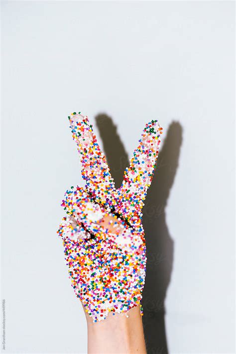 Hand Covered In Sprinkles Making Peace Sign By Stocksy Contributor