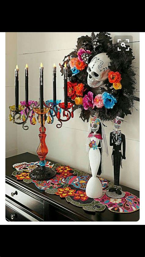 A Table Topped With Candles And Decorations Next To A Skull Head On Top