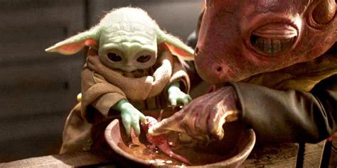 The Baby Yoda Is Being Fed From A Bowl By An Adult In Star Wars
