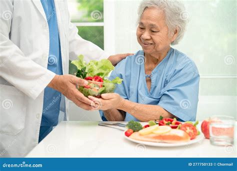 Asian Elderly Woman Patient Eating Salmon Steak Breakfast With