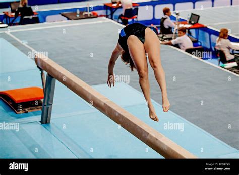 Female Gymnast Exercise Acrobatic Element On Balance Beam In Artistic Gymnastics Summer Sports