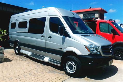 Custom Silver Mercedes Sprinter Conversion Van Parked In Front Of The