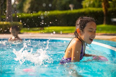 Two Happy Asian Kids Playing In The Swimming Pool By Stocksy