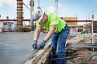 Construction worker finishing concrete at construction site - Stock ...